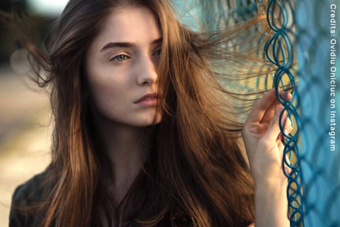 Girl standing next to a blue network, looking at the horizon. It is a photo for the Campaign I am Europe.